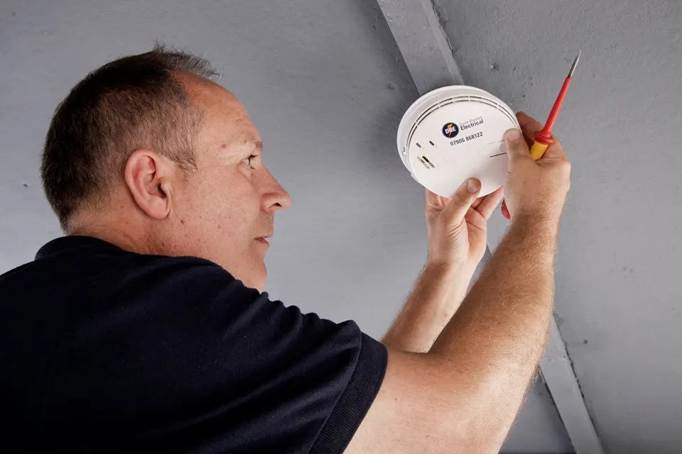 David Blundell fitting and testing a smoke detector